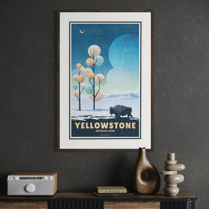 Framed Yellowstone National Park winter travel poster featuring a bison in a snowy landscape displayed in a modern office.