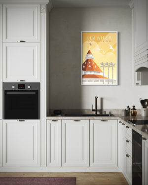 Framed San Diego Hotel del Coronado travel poster displayed on kitchen wall in bright modern interior