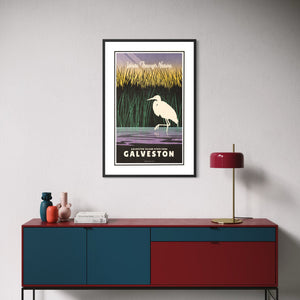 Framed Galveston Island State Park travel poster featuring a white egret in Texas coastal marshes displayed above a modern credenza.