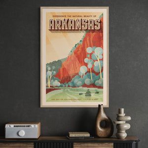 Framed travel poster for Arkansas on a dark wall with decorative items below.
