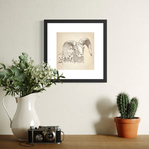 Framed Bighorn Sheep sketch above cabinet with vase, camera and cactus