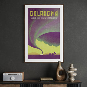 Framed Oklahoma tornado poster displayed in an office, featuring dramatic storm imagery and retro travel poster styling.