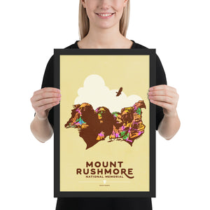 Product mockup of Minimalist giclée art print of Mount Rushmore with four U.S. Presidents and an eagle overhead. Text at the bottom reads "Mount Rushmore National Memorial, South Dakota." Bold colors against a muted background.