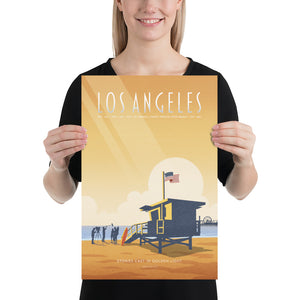 Product mockup of an Illustrated Los Angeles travel poster showing a lifeguard tower, film crew, and Santa Monica Pier at sunset in warm golden tones, retro mid-century design style.