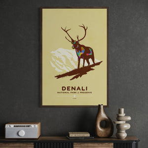 Denali National Park travel poster displayed in a natural oak frame in a mid-century office.