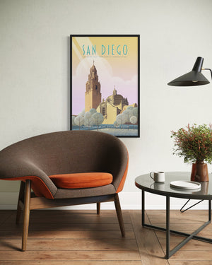 San Diego Balboa Park vintage-style poster framed in black, displayed above a mid-century modern chair in a minimalist interior