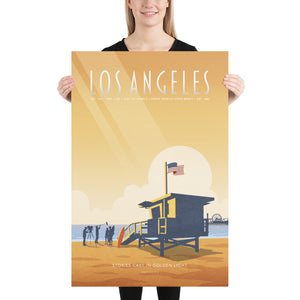 Product mockup of an Illustrated Los Angeles travel poster showing a lifeguard tower, film crew, and Santa Monica Pier at sunset in warm golden tones, retro mid-century design style.