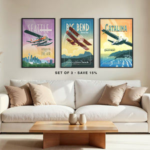 Mid century aviation wall art set of three in black frames above a sofa featuring vintage Seattle, Big Bend, and Catalina Island airplane posters