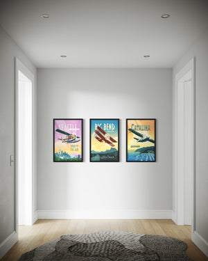 Three framed posters of vintage airplanes on a wall in a room with wooden flooring.