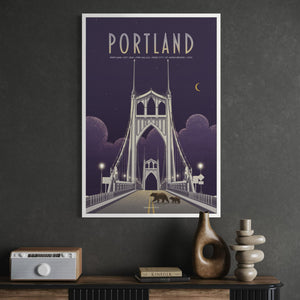A framed Portland cityscape poster hangs on a dark gray wall above a console table with decor items. The artwork shows a stylized bridge at night in purple tones with the word PORTLAND at the top.