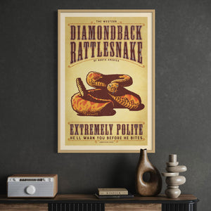Oak framed poster of a diamondback rattlesnake on a dark wall above a wooden cabinet.