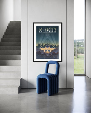 Los Angeles Griffith Observatory travel poster framed on a white wall near concrete stairs and a bold modern blue chair in a minimalist interior.