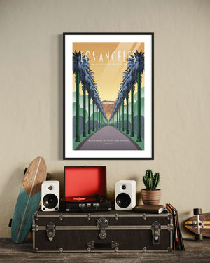 Framed Los Angeles poster of palm-lined boulevard and Hollywood sign above a record player in a cozy retro room.