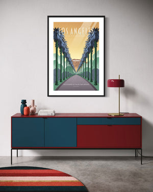 Los Angeles poster of palm boulevard and Hollywood sign framed above a red and blue credenza in a modern room.