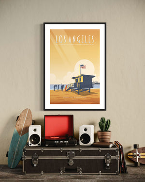 Framed Los Angeles poster of Santa Monica Beach hanging above a record player and surfboard, styled in a cozy retro room.