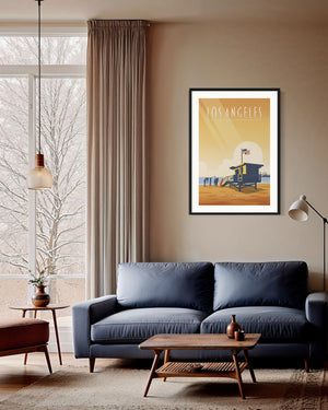 Los Angeles poster print of Santa Monica Beach displayed above a mid-century sofa in a bright living room.