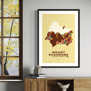 Minimalist giclée art print of Mount Rushmore with four U.S. Presidents and an eagle overhead. Text at the bottom reads "Mount Rushmore National Memorial, South Dakota." Bold colors against a muted background.