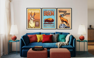 Set of three vintage-style Western animal posters featuring pronghorn, bison, and bighorn sheep displayed above a living room sofa