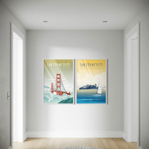 Two framed posters of San Francisco on a wall in a hallway..