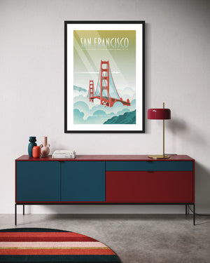 Framed San Francisco Golden Gate Bridge poster displayed above a modern red and blue credenza with decorative vases, a lamp, and a striped rug in a colorful mid-century–inspired living space.