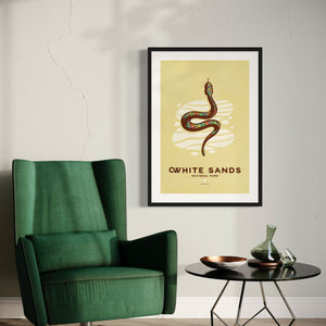 Modern, minimalist giclée art print of White Sands National Park & Preserve in Alaska. This simple and classy poster depicts a Diamondback Rattlesnake slithering across the white sands of the park. It has the words “White Sands National Park, New Mexico”  at the bottom. The print’s muted overall background color allows the bold and vibrant colors of the main image to pop. 