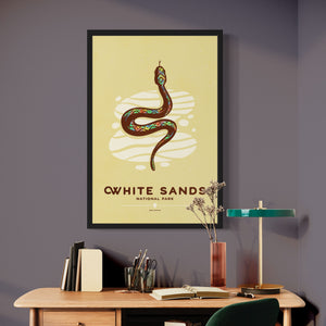 Modern, minimalist giclée art print of White Sands National Park & Preserve in Alaska. This simple and classy poster depicts a Diamondback Rattlesnake slithering across the white sands of the park. It has the words “White Sands National Park, New Mexico”  at the bottom. The print’s muted overall background color allows the bold and vibrant colors of the main image to pop. 