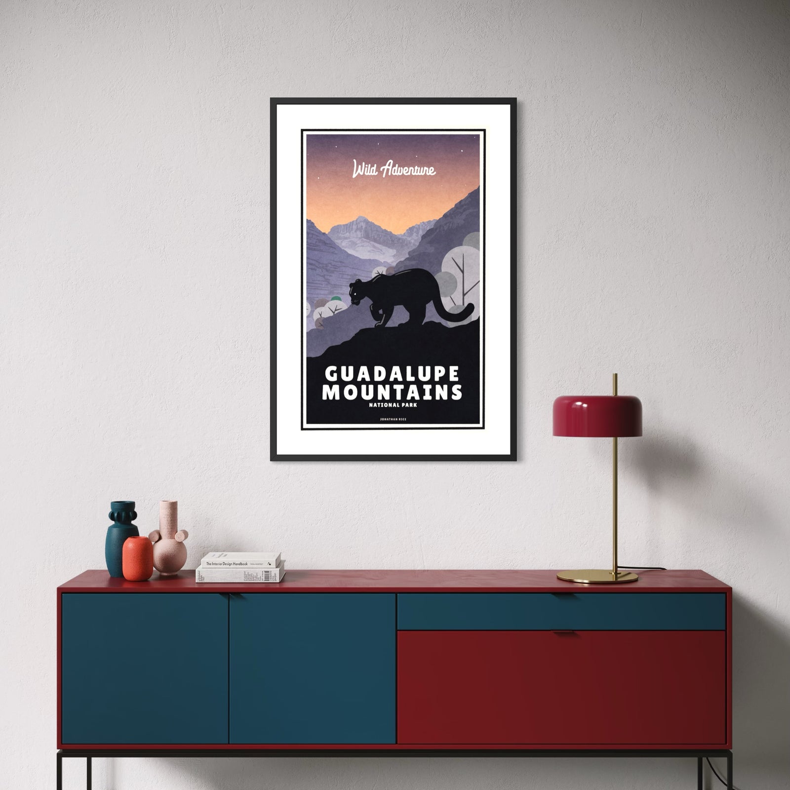 Vintage-style Guadalupe Mountains National Park poster featuring a mountain lion silhouetted on a rocky overlook beneath a colorful desert sunset, with layered mountain peaks, canyon landscape, and bold retro typography inspired by classic travel posters.