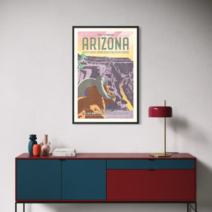 Framed Grand Canyon vintage travel poster displayed above a modern credenza, featuring a bighorn sheep and colorful Arizona canyon landscape.