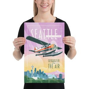 Retro style giclée art print of a De Havilland Canada DHC-2 Beaver floatplane flying over Seattle, Washington.. It has the words “Seattle Vintage Air Tours” at the top. The print’s soft purples, yellows, blues and greens create a stunning backdrop for the classic floatplane with it’s touch of red. There are additional words a the bottom that says “The best way to see the Emerald City is from the air.” Print size  12" x 18"