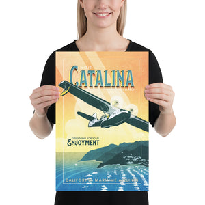 Retro style giclée art print of a PBY Catalina Flying Boat Aircraft flying over Catalina Island, California. It has the words “Visit Catalina Island” at the top. The print’s cool blues and greens combined with the warm sunset sky creates a stunning backdrop for the classic flying boat with bright cool color and yellow highlights. There are additional words a the bottom that says “Everything for your Enjoyment. California Maritime Airlines.” Print size 12" x 18"