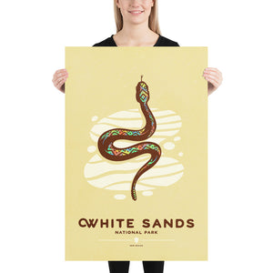 Modern, minimalist giclée art print of White Sands National Park & Preserve in Alaska. This simple and classy poster depicts a Diamondback Rattlesnake slithering across the white sands of the park. It has the words “White Sands National Park, New Mexico”  at the bottom. The print’s muted overall background color allows the bold and vibrant colors of the main image to pop. 