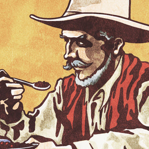 Detail of Bold graphic giclée art print of a Cowboy eating breakfast with the words “Beans for Breakfast”. Print is an ink portrait, with color, of a cowboy seated on the grounded with a plate of beans in hand. 