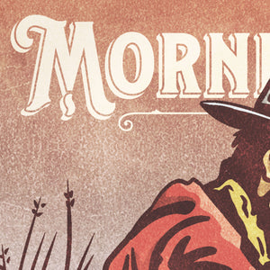 Detail of Bold graphic giclée art print of a Cowboy drinking coffee with the words “Morning Coffee”. Print is an ink portrait, with color, of a cowboy seated on the grounded with a cup of coffee in hand. 