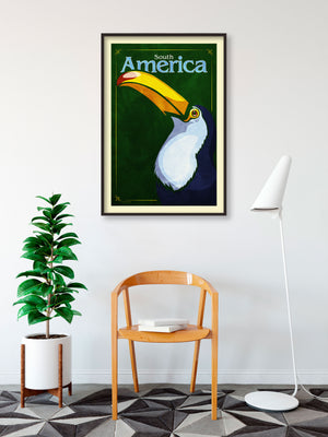 Bold graphic giclée art print of a South American Toucan. Print shows a South American Toucan blending into a dark green background and overlapping the words “South America”.
