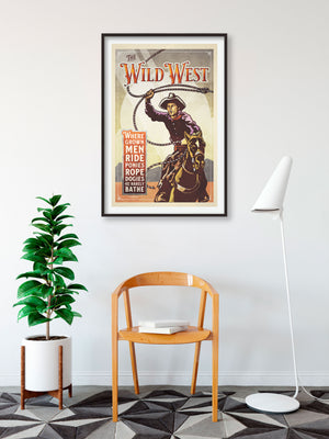 Bold graphic giclée art print of a Cowboy riding a horse and swinging a rope with the words “The Wild West”. Print is an ink portrait, with color, and a sky background with sun rays.