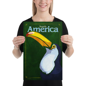 Bold graphic giclée art print of a South American Toucan. Print shows a South American Toucan blending into a dark green background and overlapping the words “South America”. Size 12" x 18"