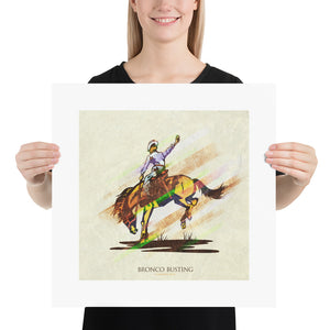 Retro styled art print of Bronco Busting. The prints depicts a cowboy riding a bronco. The bold graphic lines are complemented by colorful streaks giving the piece a sense of movement. The print has the words “Bronco Busting” on it. Size 18"x18"