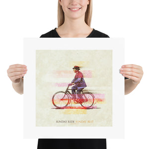 A retro styled art print of a man out for a Sunday ride on his bicycle in his Sunday best suit and hat. Bold graphic lines are complemented by colorful streaks giving the piece a sense of movement. The print has the words “Sunday Ride Sunday Best” on it. Size 18"x18"